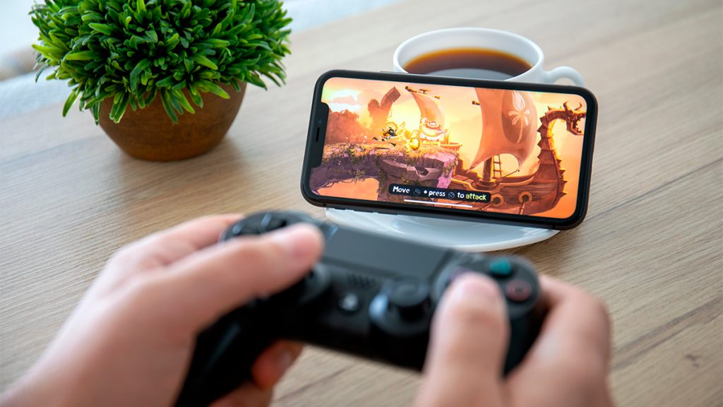 Pessoa jogando em iPhone usando controle do PlayStation 4