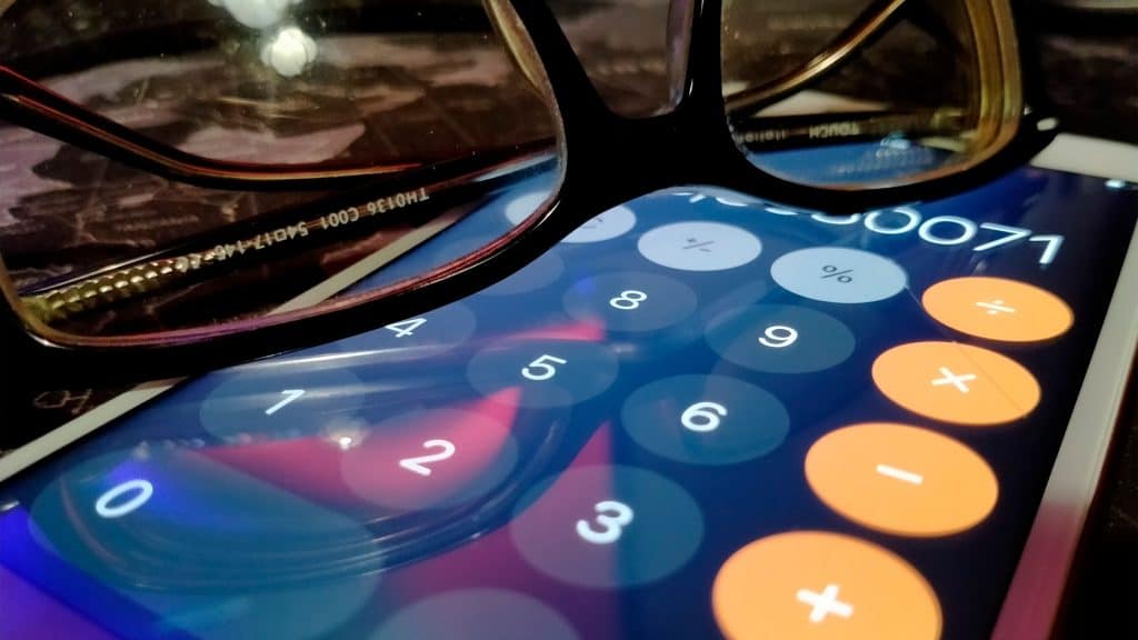 Óculos em cima de iPhone com calculadora aberta