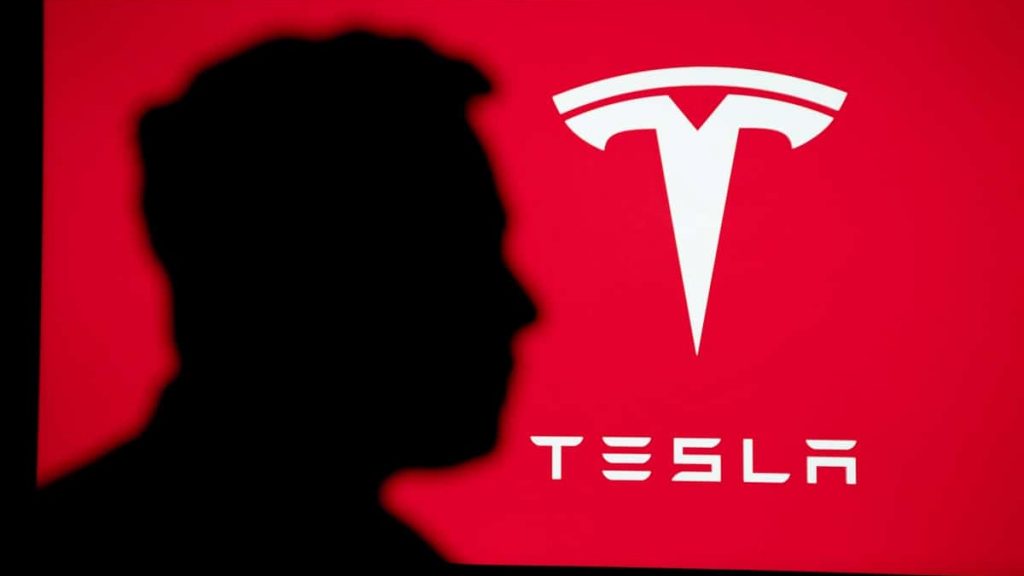 Silhueta do Elon Musk com logotipo da Tesla ao fundo